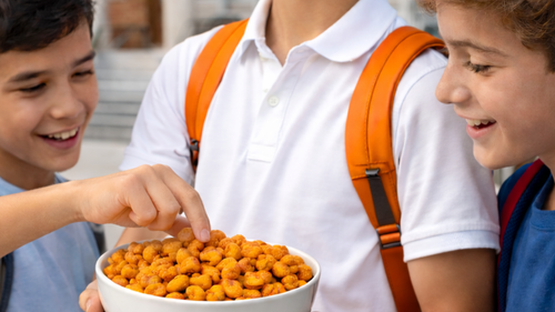 Niños_comiendo_botanas_saludables_en_la_escuela_snack_tipo_maicitos_para_cafeterías_escolares