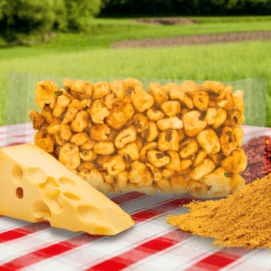 Maicitos inflados al vapor sabor queso en empaque sin etiqueta sobre un mantel a cuadros. Acompañado de queso y especias.
