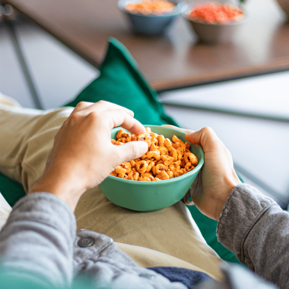 manos sosteniendo tazon de maicitos sabor queso chile disfrutando una botana saludable marca blofis