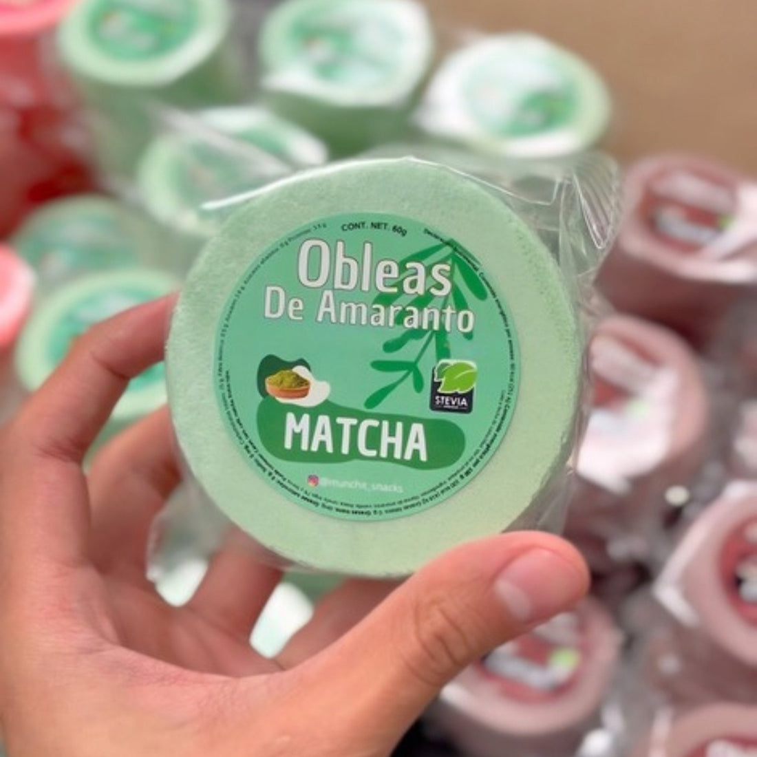 Mano sosteniendo una oblea de amaranto sabor Matcha