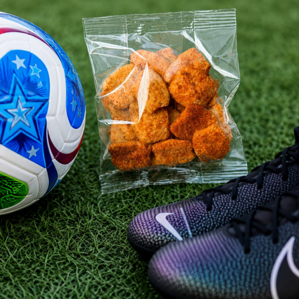 Bolsa de chicharrón de garbanzo junto a un balón en el pasto