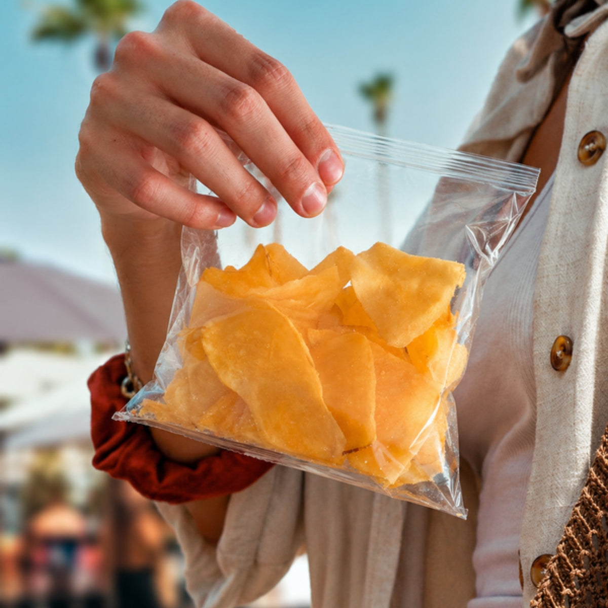 Mano sacando chips de jícama Limón y Sal de su bolsa