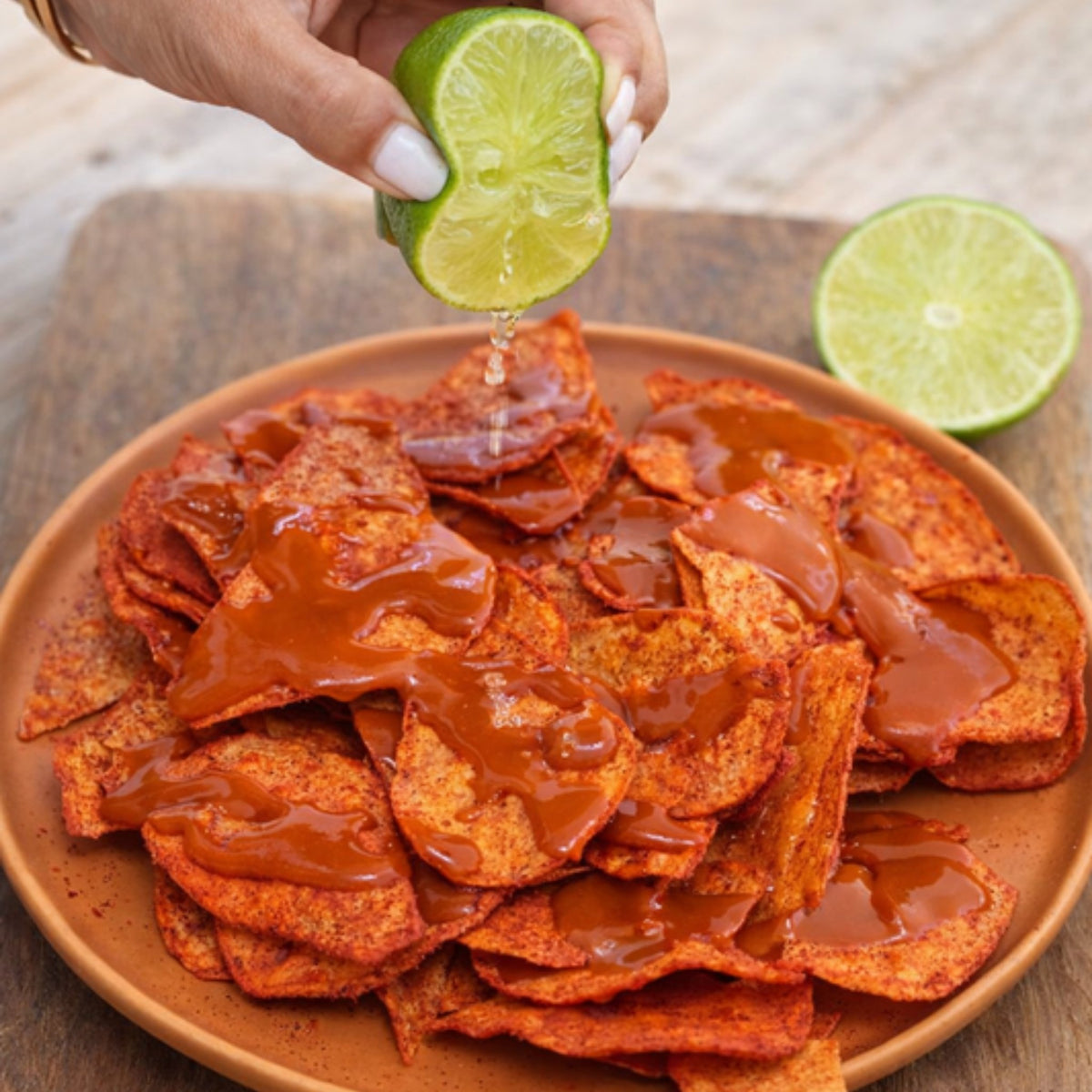 Chips de camote Fuego con limón exprimido en un plato de barro