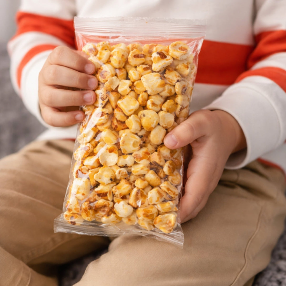Niño sosteniendo una bolsa de maicitos de 50 g