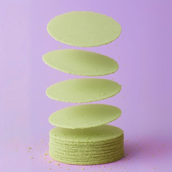 obleas de amaranto sabor matcha cayendo en torre sobre fondo morado snacks saludables horneados